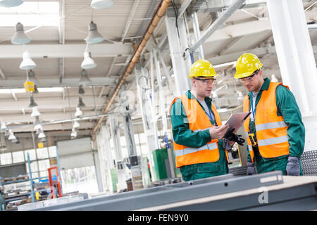 Workers in protective workwear with clipboard in factory Stock Photo
