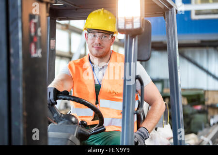 Portrait worker driving forklift in factory Stock Photo