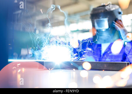 Welder using welding torch in factory Stock Photo