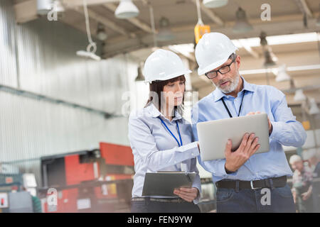 Engineers with laptop in factory Stock Photo
