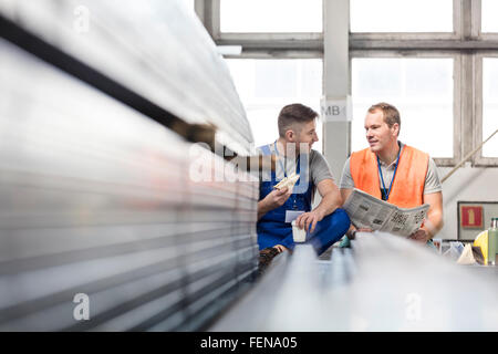 Workers enjoying coffee break in steel factory Stock Photo