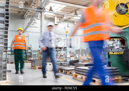 Engineer and works walking in factory Stock Photo