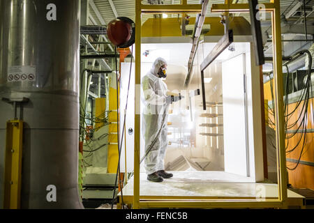 Worker operating machinery in factory Stock Photo