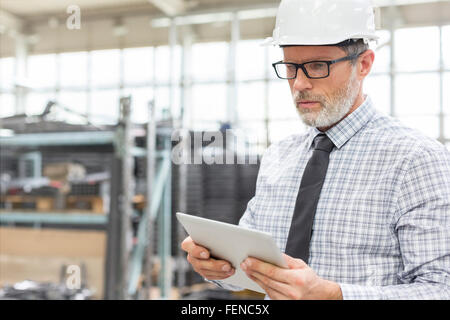 Engineer using digital tablet in factory Stock Photo