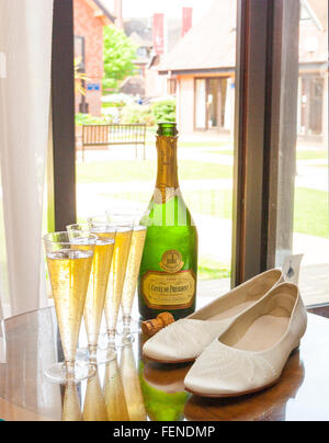 Four glass, Champagne and shoes on the table for wedding day Stock Photo