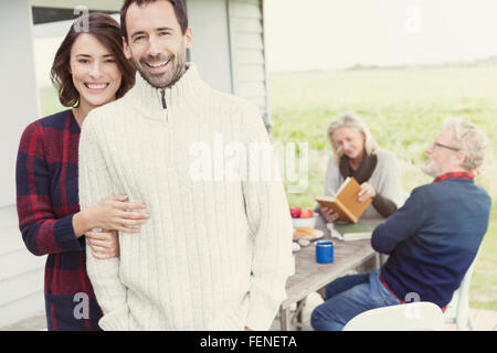 Portrait smiling brunette couple in sweaters on patio Stock Photo