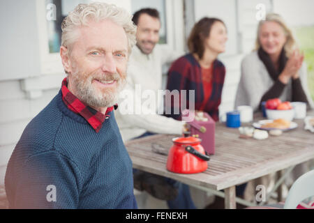 Portrait smiling senior man enjoying breakfast with family on patio Stock Photo