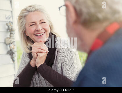 Smiling senior woman talking to man Stock Photo