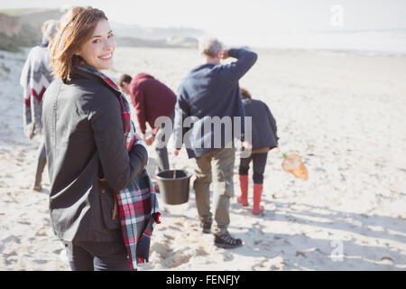 Portrait smiling woman walking on sunny beach with family Stock Photo