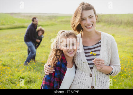 Portrait smiling mother and daughter in meadow with wildflowers Stock Photo