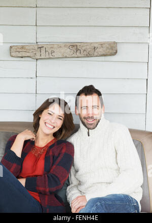 Portrait smiling couple on porch below “The Shack” sign Stock Photo