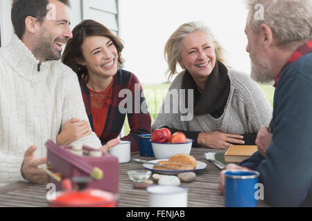 Couples talking and enjoying breakfast at patio table Stock Photo