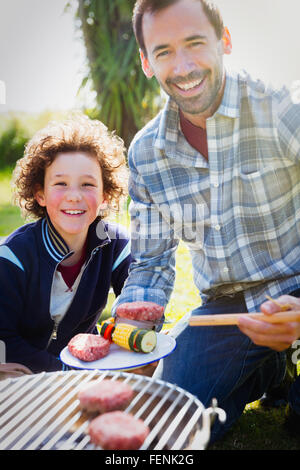 Portrait smiling father and son barbecuing Stock Photo