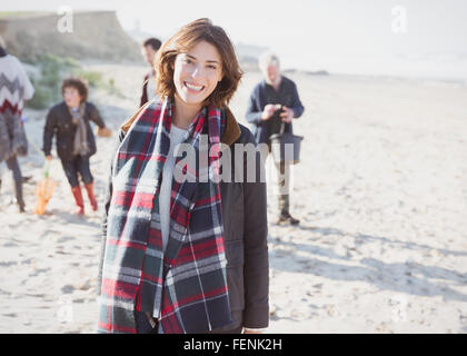 Portrait smiling woman in plaid scarf with family on beach Stock Photo