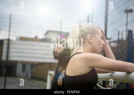 Young woman taking a break, leaning on football goal Stock Photo