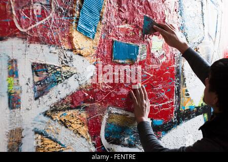 Male artist creating painted artwork Stock Photo