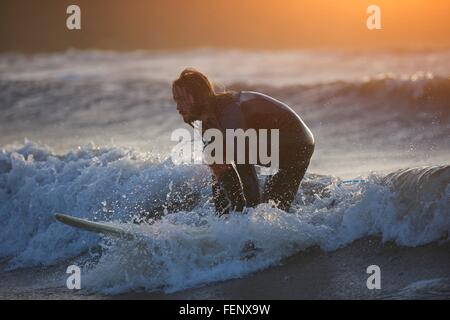 Young male surfer surfing on ocean wave, Devon, England, UK Stock Photo
