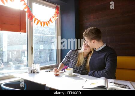 Romantic young couple on date in cafe window seat Stock Photo
