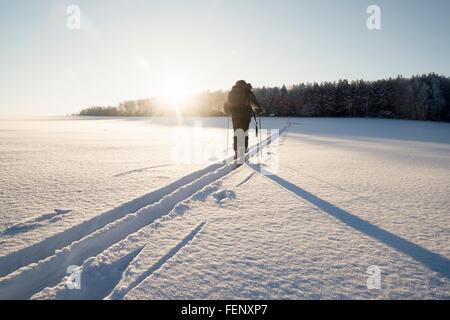 Rear view of man walking along snow tracks, Ural, Russia Stock Photo