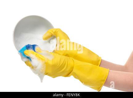 Close up of female hands in yellow protective rubber gloves washing white bowl with blue cleaning sponge against white Stock Photo