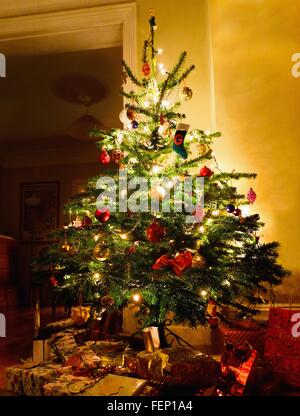 Illuminated christmas tree with gifts underneath Stock Photo