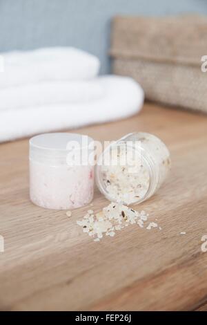 Tub of bath salts spilling on dresser Stock Photo