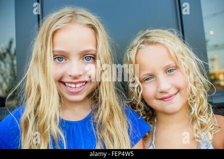 Portrait of blond haired and blue eyed sisters at sidewalk cafe Stock Photo