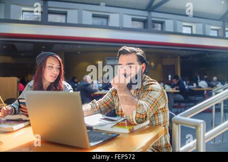 Two adult college students working on laptop at classroom desk Stock Photo
