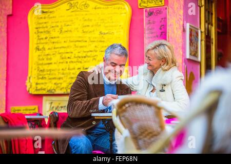 Mature couple drinking coffee at colorful sidewalk cafe, Majorca, Spain Stock Photo