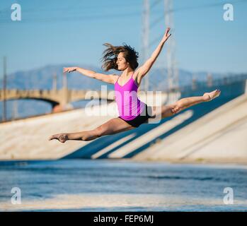 Dancer in mid air, arms raised doing the splits, Los Angeles, California, USA Stock Photo