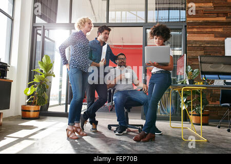 Multiracial group of designers meeting in modern office discussing work. Young entrepreneurs having a meeting for new creative p Stock Photo