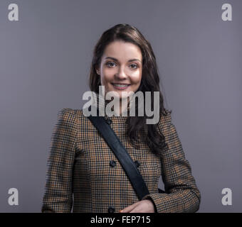 Young woman in checked brown winter coat. Studio shot. Stock Photo