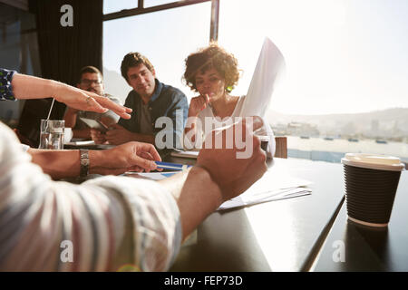 Hands of young man and woman explaining business plan to colleagues, Creative team having a meeting in office. Focus on hand and Stock Photo