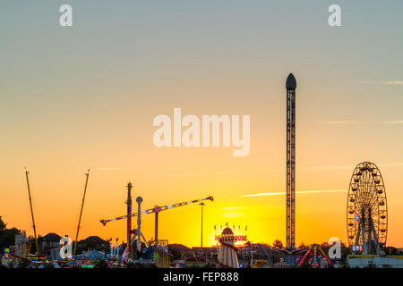 UK fairground rides against a sunset, Goose Fair, Nottingham, England, UK Stock Photo