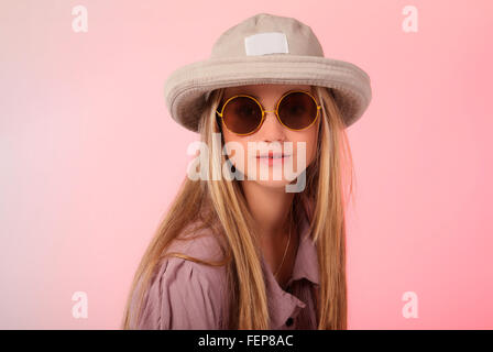 A beautiful young teen blond photo in a studio with soft pink background. Stock Photo