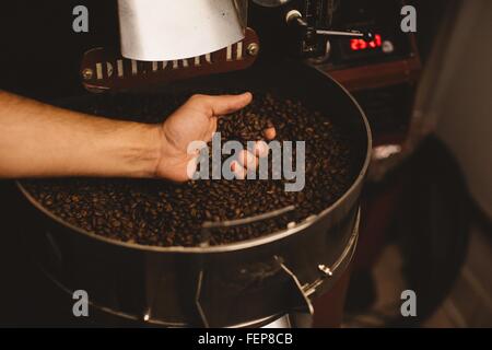 Man holding roasted coffee beans Stock Photo