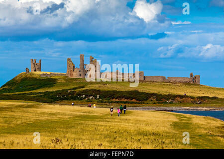 The ruins of Dunstanburgh Castle in Northumberland north east England UK seen from the coast path from Craster village Stock Photo