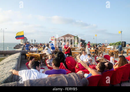 Crowds taking in the sunset at Cafe del Mar, on the colonial stone wall surrounding the old town area of Cartagena, Colombia Stock Photo