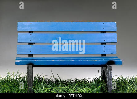 Old blue park bench on green grass. Stock Photo