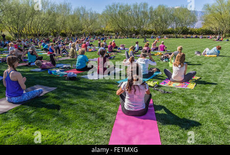 A large group of men and women of all ages go through their poses at an outdoor yoga class at the Sunnylands Center & Garden. Stock Photo