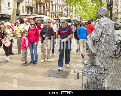 Tourist giving money to human statue busker on Las Ramblas in Barcelona, Spain, Europe Stock Photo