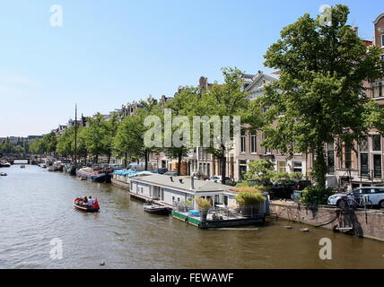 Houseboats moored along tree-lined Keizersgracht canal in summer, historic inner city of Amsterdam, Netherlands Stock Photo