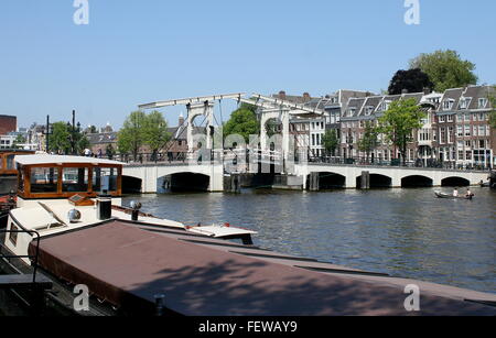 Magere Brug or  'Skinny  Bridge'  spanning Amstel river in the centre of Amsterdam, The Netherlands, houseboat moored in front Stock Photo