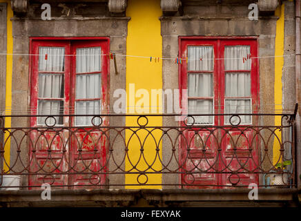 Balcony in Porto. Red doors contrast with yellow trim in a display of colour in Porto, a historical town in Portugal. Stock Photo