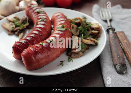 Grilled sausages with mushroom on white plate Stock Photo