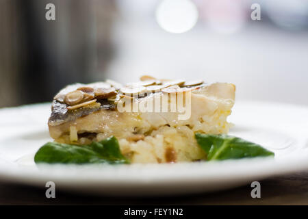 Hake and almond risotto. Hake fillet on a bed of almond, lemon & olive oil risotto: Risotto de Merlu Stock Photo