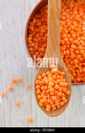 Red lentils in spoon on a wooden table Stock Photo