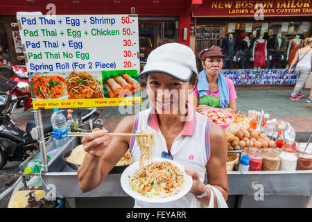 BANGKOK, THAILAND: Tourists wearing elephant-adorned trousers order food at  a stall on Khao San Road in Bangkok, Thailand on August 22nd, 2019.  Bangkok's bustling Khao San Road - a strip famous among