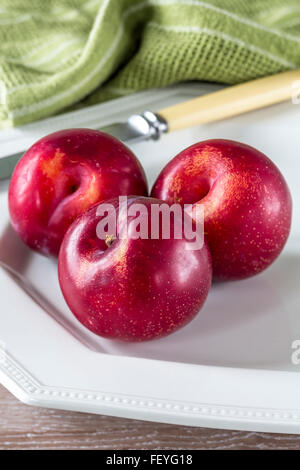 three nectarines on a white plate