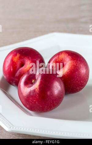 three nectarines on a white plate Stock Photo